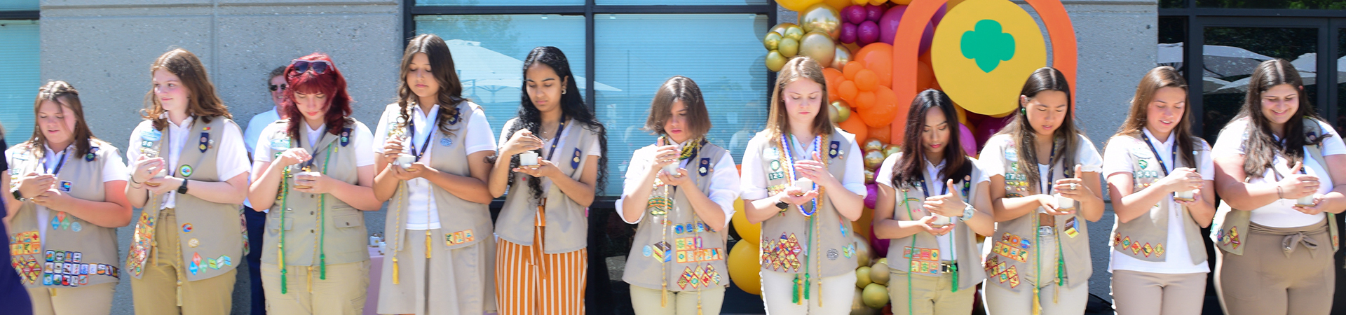  gold award girl scouts standing in a line with candles 