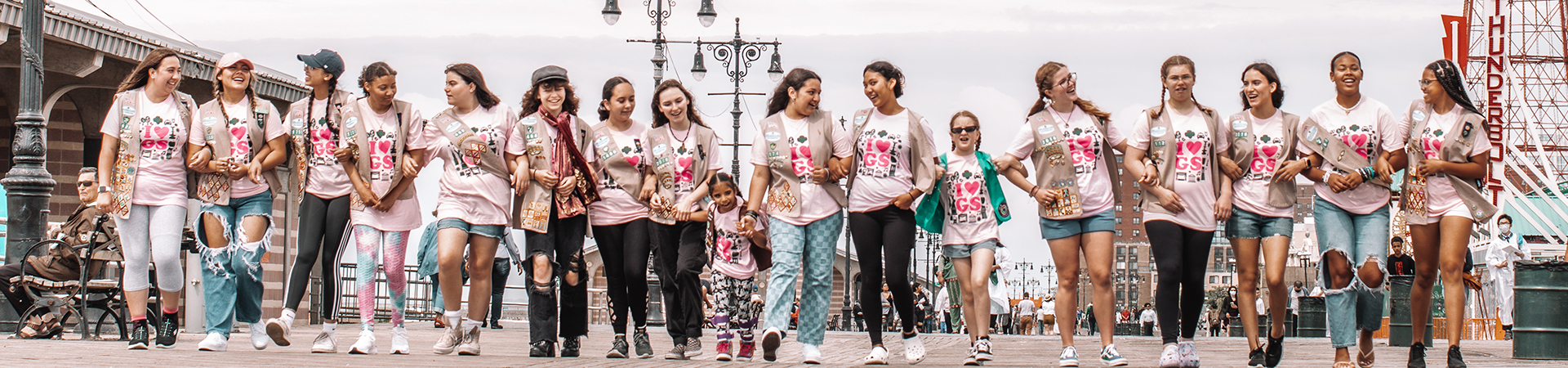  large group of girls walking down a boardwalk 